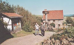 Besucher im Mühlenhof Museum - links das Bienenhaus - im Hintergrund der Backspeicher